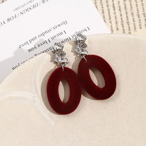 Detailed close-up of burgundy flocked oval earrings with silver liquid metal texture