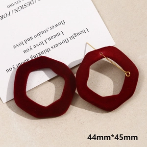 Close-up of red flocked irregular earrings with 44mm size detail and gold metal stud