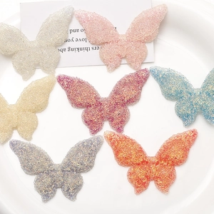 Macro detail of butterfly resin charms with colorful glitter sugar powder coating