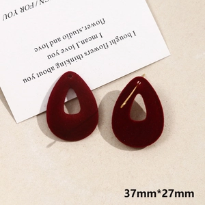 Close-up of teardrop-shaped 37x27mm wine red velvet earrings with gold metal posts