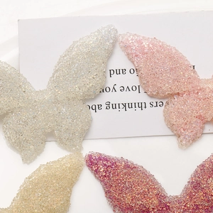 Macro detail of butterfly resin charms with glitter bead texture for DIY accessories