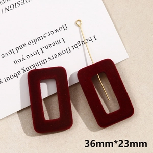 Close-up of rectangle velvet jewelry pendants in burgundy red with gold metal rods