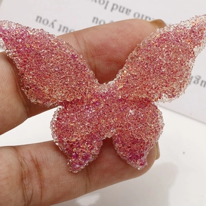 Macro detail of large butterfly resin patch with pink sequins and beaded texture