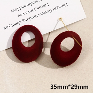 Close-up of burgundy flocked hollow round earrings with gold metal bar details