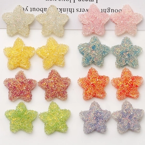Macro detail of star-shaped resin charms with colorful glitter sugar texture for DIY crafts