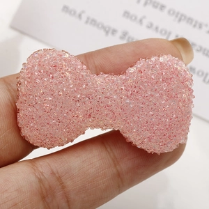 Dettaglio macro di un fiocco rosa glitterato in resina per accessori fai-da-te