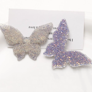 Macro detail of large resin butterfly charms with glitter sequins for DIY jewelry