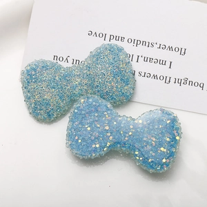 Dettaglio di fiocchi in resina blu scintillante con glitter laser per accessori gioielli DIY