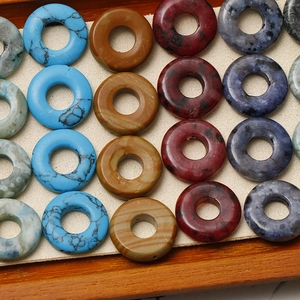 Detailansicht bunter runder Natursteinperlen für DIY-Schmuck in einem Holztablett