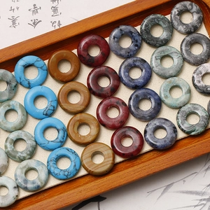Nahaufnahme bunter Naturstein-Donut-Perlen mit einzigartigen Texturen auf Tablett