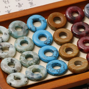 Makro-Detail von gemischten Naturstein-Donut-Perlen in einer Holzschale für DIY