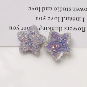 Detailed close-up of 20mm sparkly resin star charms with purple sequins for DIY jewelry