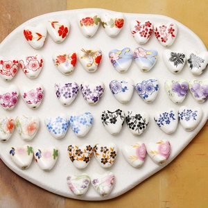 Detailed macro view of heart-shaped ceramic beads with hand-painted floral patterns for DIY