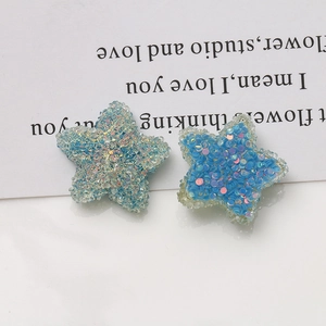 Close-up of 20mm blue glitter resin star charms for DIY jewelry making accessories