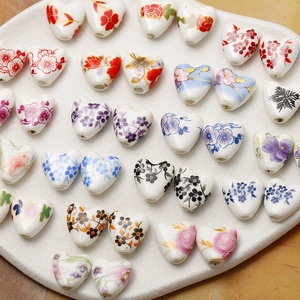 Detail of heart-shaped ceramic beads with hand-painted floral patterns for DIY jewelry