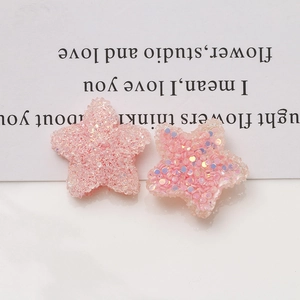Detailed close-up of pink glittery resin star charms for DIY jewelry making and crafts