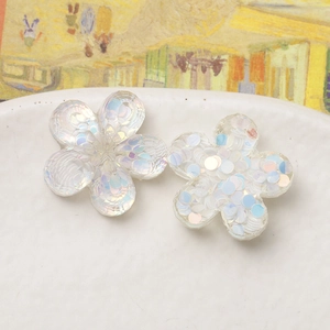 Macro shot of colorful iridescent sequin flower resin charms for DIY hair accessories