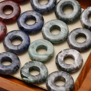 Nahaufnahme bunter Donut-Perlen aus Naturstein für DIY-Schmuckherstellung in Holzschale