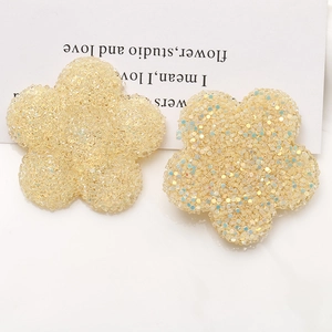 Makroaufnahme von zwei gelben Harzblumen mit Glitzer-Matt-Textur für DIY-Schmuck