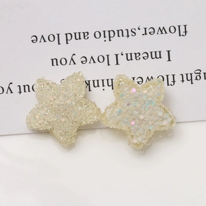 Close-up of star-shaped resin charms with iridescent sequins for DIY jewelry making