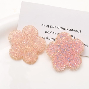 Nahaufnahme von rosa Resin-Blütenanhängern mit Glitzer-Finish für DIY-Schmuck