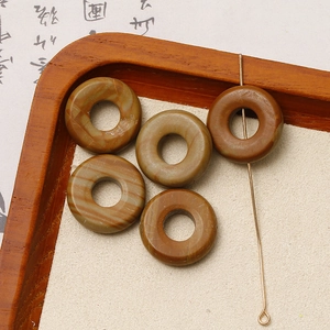 Nahaufnahme von 5 Natursteinperlen mit Marmortexter für Schmuck-DIY in einer Holzschale