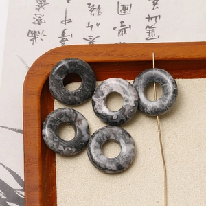 Makroaufnahme von Naturstein-Donut-Perlen mit grauer Marmortextur für DIY-Schmuck