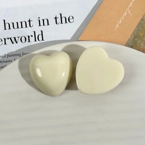 Detailed macro view of two cream heart resin charms for DIY jewelry and accessories