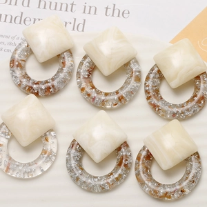 Detail view of geometric earrings with cream marble studs and silver foil resin rings