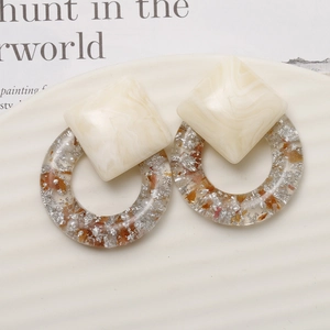 Minimalist marble resin earrings with silver foil inlays on white ceramic tray