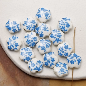 Macro detail of plum blossom ceramic beads with blue flower patterns for jewelry making