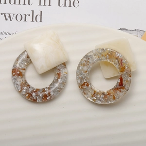 Detail of resin earrings with marble cube and silver foil in transparent ring