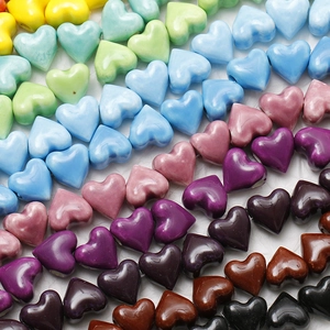Macro detail of rainbow gradient ceramic heart beads with high-gloss glazed finish for DIY jewelry