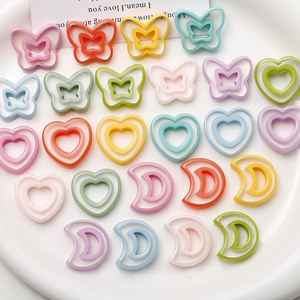 Macro view of pastel resin charms in butterfly, heart and crescent shapes for DIY jewelry