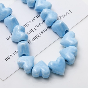 Close-up of blue heart ceramic beads with marble texture for DIY jewelry making