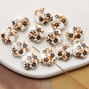 Macro shot of hand-painted floral ceramic flower beads with pre-drilled holes for DIY jewelry