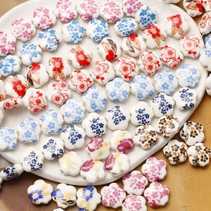 Hand-painted flower ceramic beads for DIY jewelry making in a white ceramic tray
