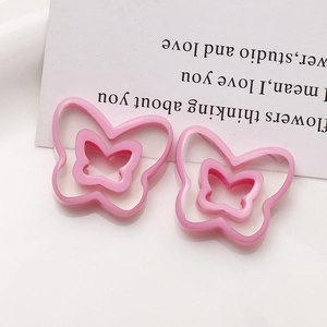 Detail of pink resin butterfly charms with double-layer hollow design and polished finish