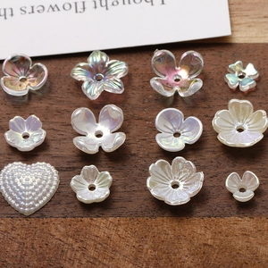 Macro detail of iridescent acrylic flower and heart beads for DIY jewelry making