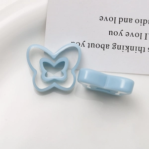 Macro view of two light blue hollow butterfly resin charms for DIY jewelry accessories