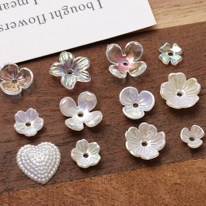 Close-up of iridescent acrylic flower and heart beads with pearl finish for DIY jewelry