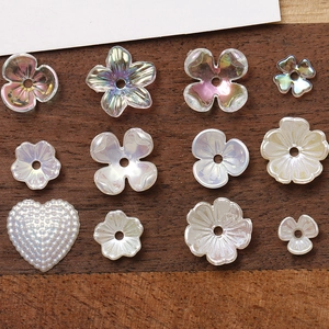 Detailed macro view of pearlescent acrylic flower and heart beads for DIY jewelry making