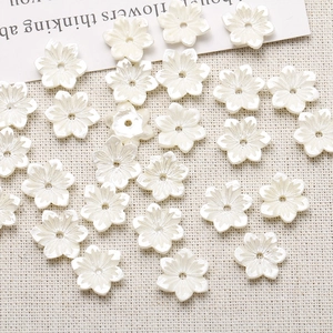 Close-up of pearl white five-petal resin flower beads with center holes for DIY crafts