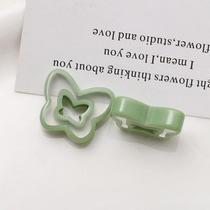 Detail of light green butterfly resin charms for DIY jewelry making on white background