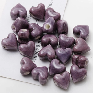 Macro shot of purple glazed heart ceramic beads with side holes for DIY jewelry