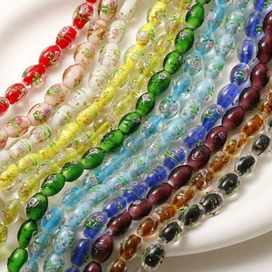 Macro shot of colorful handmade oval glass beads with hand-painted floral patterns