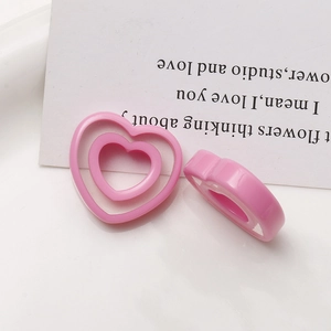 Macro shot of double-layered hollow pink resin heart charms for DIY jewelry making