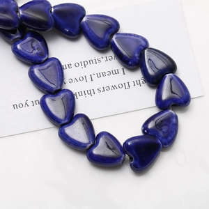 Détail macro de perles en céramique bleu foncé en forme de cœur pour bijoux DIY