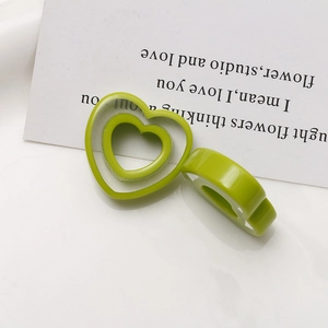 Detail of translucent green resin heart rings featuring hollow and wide-band designs