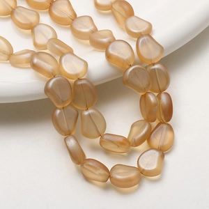 Gros plan de perles en verre dépoli ambre irrégulières pour la création de bijoux DIY